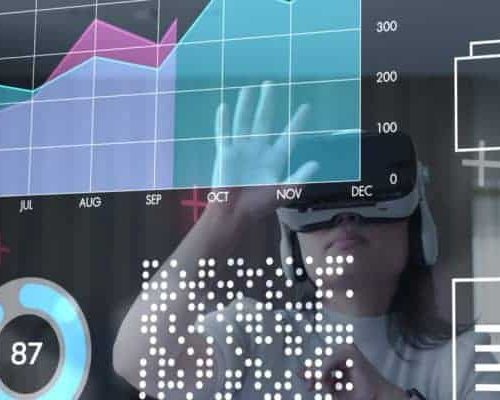 Person wearing virtual reality headset interacting with floating data charts and graphs showing monthly trends and numerical data.