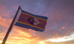Eswatini / Swaziland Flag on Flagpole by Evening Sunset Sky